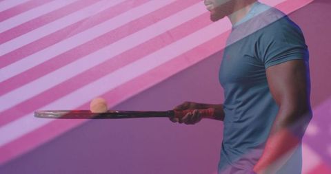 Energetic tennis player balancing racket under colorful lights