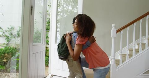 Joyful Mother Embracing Son with School Bag in Comforting Home Setting - Download Free Stock Images Pikwizard.com