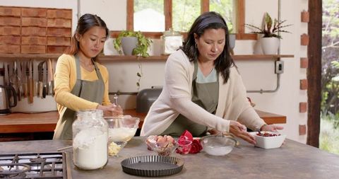 Mother and Daughter Cooking Together in Rustic Kitchen