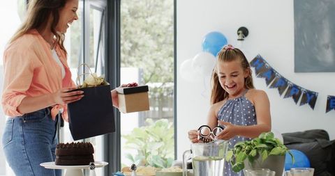 Joyful Mother and Daughter Preparing Birthday Lunch in Bright Living Room