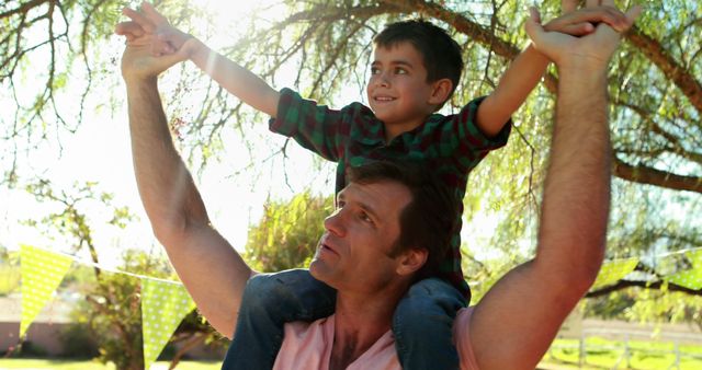 Father Joyfully Carrying Son on His Shoulders in Outdoor Park - Download Free Stock Images Pikwizard.com