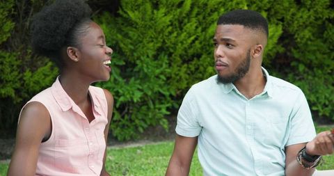 Young Couple Enjoying Picnic in Park Laughing Together