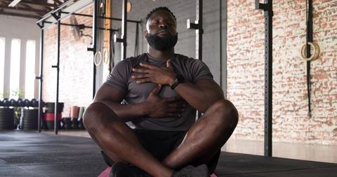 African american man meditating in modern gym for mindful fitness