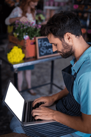 male florist in apron using laptop in transparent flower shop - Download Free Stock Videos Pikwizard.com
