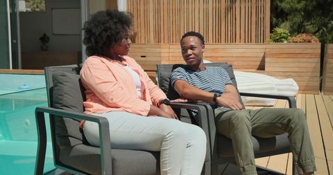 African American Couple Relaxing by Pool in Summer Sunshine