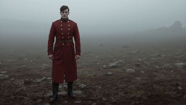 Lone Soldier in Red Uniform Standing in Misty Landscape