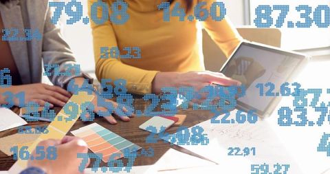 Design team collaborating on branding with tablet and color swatches, analytics overlay