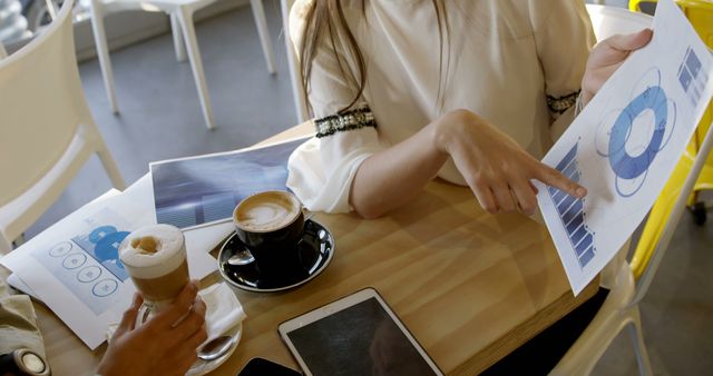 Business Meeting in Coffee Shop with Data Charts and Tablet - Download Free Stock Images Pikwizard.com