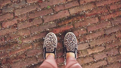 Street fashion statement with leopard print sneakers on brick pathway