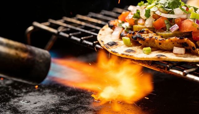 Flame-charred tortilla topped with grilled chicken, pico de gallo and torch flames