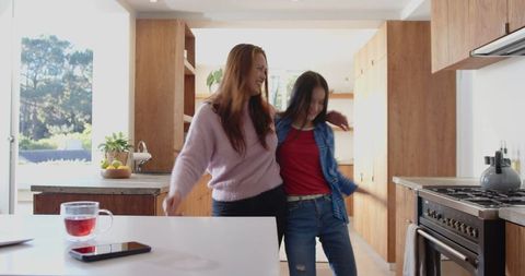 Mother and Daughter Dancing in Modern Kitchen
