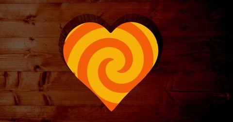 Rotating Orange Spiral over Heart-Shaped Cutout in Wood