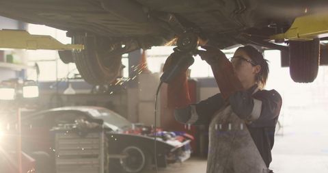 Female Mechanic Brightening Garage with Welding Light - Download Free Stock Images Pikwizard.com