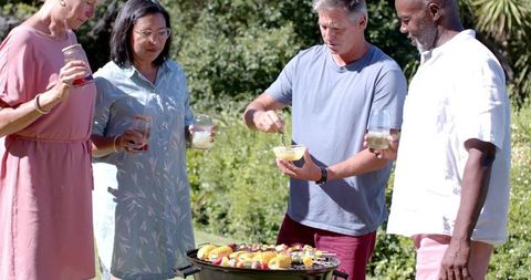 Friends Cooking and Enjoying a Garden Barbecue Together