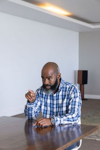 Confident African American Man Gesturing While Discussing at Table