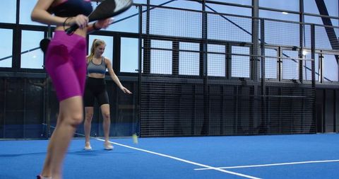 Women Enjoying Intense Paddle Tennis Match Indoors