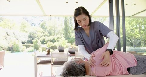 Caregiver Aids Senior Woman in Outdoor Therapy Session