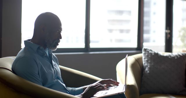 Senior man using laptop while sitting on sofa in living room - Download Free Stock Images Pikwizard.com