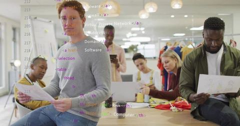 Creative team discussing printed sketches and reviewing fashion samples in design studio