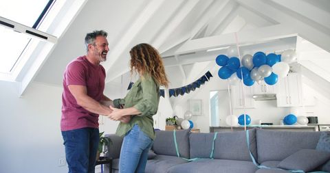 Cheerful Couple Dancing at Home Celebration Party with Balloons