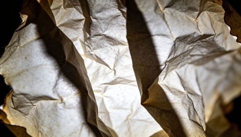 Backlit crumpled parchment texture with warm glowing creases