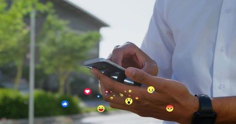 Man tapping smartphone on campus with floating social media reaction icons and copy space