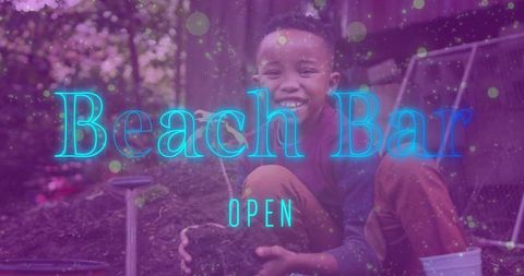 Smiling boy planting seedling in backyard garden with neon beach bar open overlay