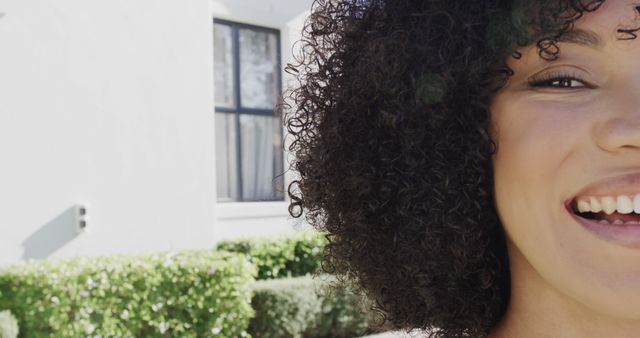 Close-Up of Woman with Curly Hair Smiling Outdoors - Download Free Stock Images Pikwizard.com