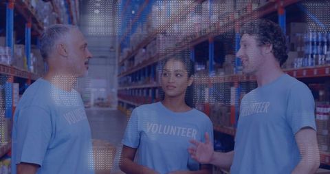 Volunteer team discussing distribution logistics in warehouse aisle