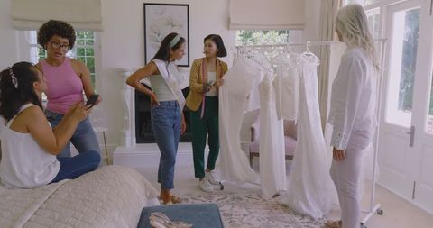 Bride-to-be Choosing Wedding Dress with Friends in Cozy Living Room