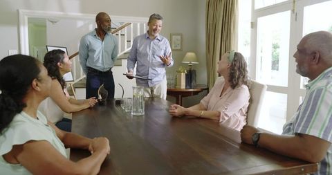 Seniors Engaging in Lively Discussion Around Dining Table at Home