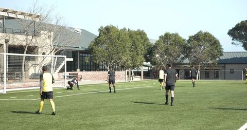 Soccer practice: player kicking ball on sunny field