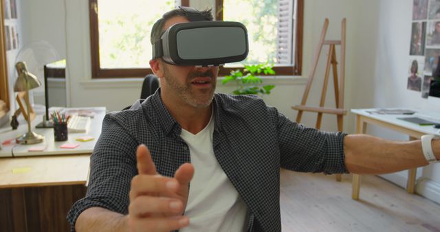 Man Experiencing Virtual Reality in Modern Home Office - Download Free Stock Images Pikwizard.com