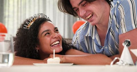 Smiling couple celebrating birthday with cupcake candle