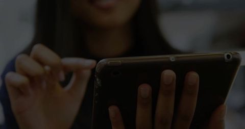 Technologically savvy asian woman using a tablet in office