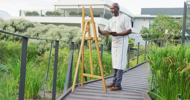 Male Artist Painting Outdoors on Wooden Pathway in Garden - Download Free Stock Images Pikwizard.com