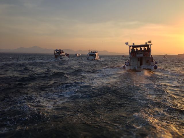 Boats sailing on ocean at sunset - Download Free Stock Photos Pikwizard.com