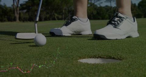 Female Golfer Positioning Putter and Ball on Green with Financial Chart Overlay