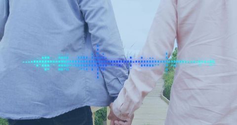 Couple walking hand in hand along coastal boardwalk with blue soundwave overlay
