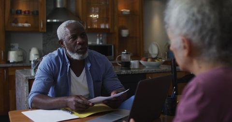 Senior Couple Managing Finances Together at Kitchen Table