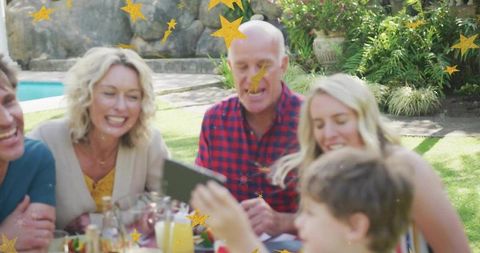 Multi Generation Family Enjoying Outdoor Gathering with Smartphone