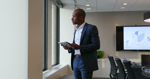 Confident Businessman Using Digital Tablet in Modern Office