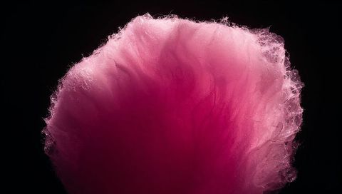 Glowing Pink Cotton Candy Tuft Floating with Rim Light Highlighting Fibrous Sweet Texture
