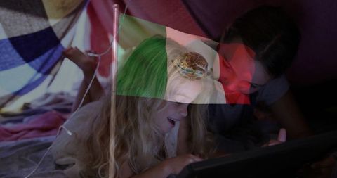 Kids enjoying digital entertainment in cozy blanket fort retreat