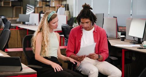 Young professionals collaborating on documents in modern office