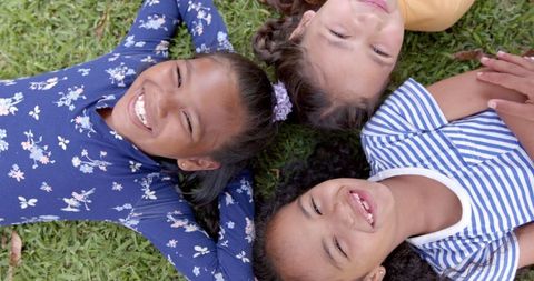 Smiling Schoolgirls Lying on Grass Enjoying Sunny Day