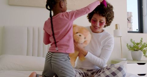 Mother and Daughter Bonding on Bed with Teddy Bear