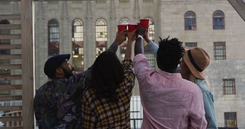 Diverse Friends Celebrating on Rooftop Cheers with Cups
