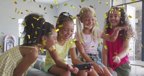 Joyful Diverse Girls Enjoying Smartphone with Gold Confetti Celebration