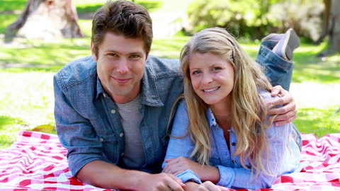 Smiling Couple Enjoying Picnic in Sunny Park